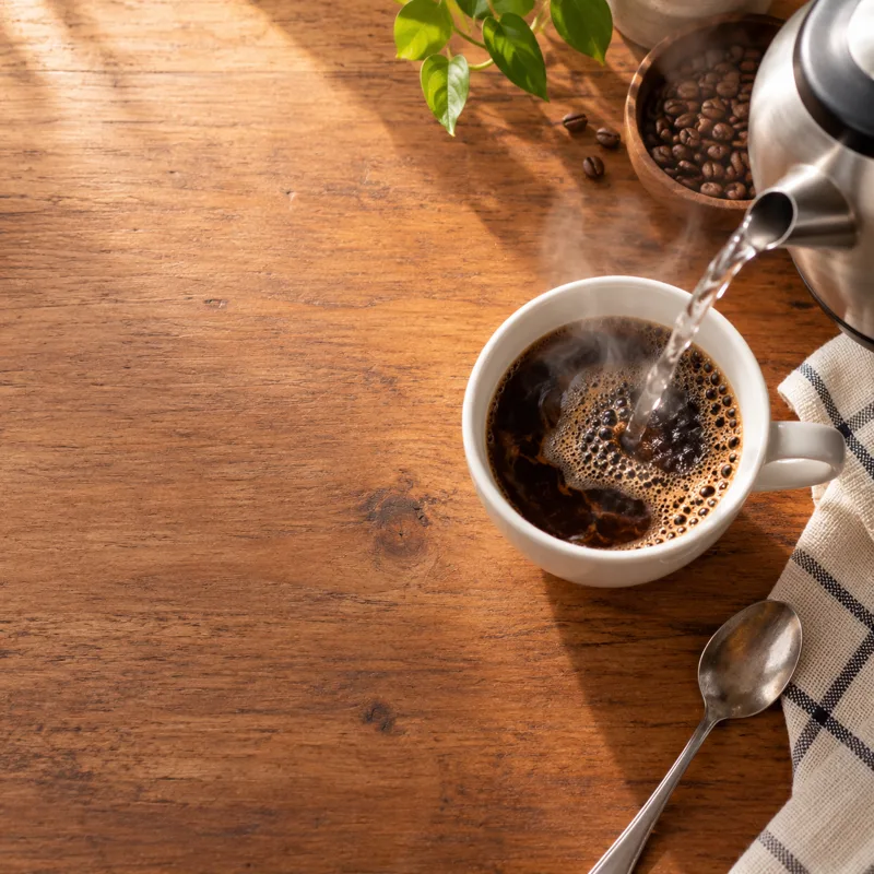 Air panas dituang ke dalam cawan kopi